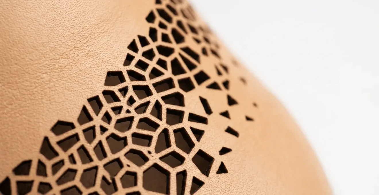 Vue macro d'une découpe laser haute précision sur cuir de sneaker avec motifs géométriques complexes