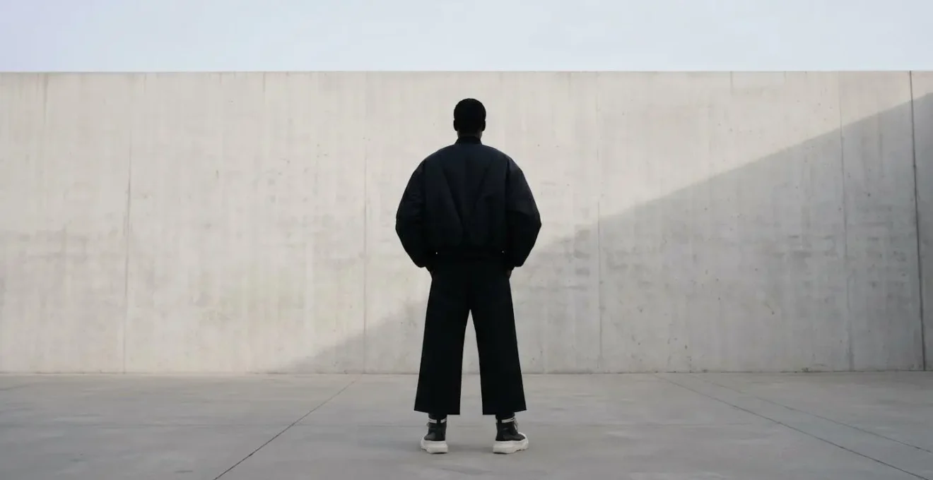 Silhouette complète montrant l'équilibre entre une veste oversize et des baskets montantes avec pantalon large