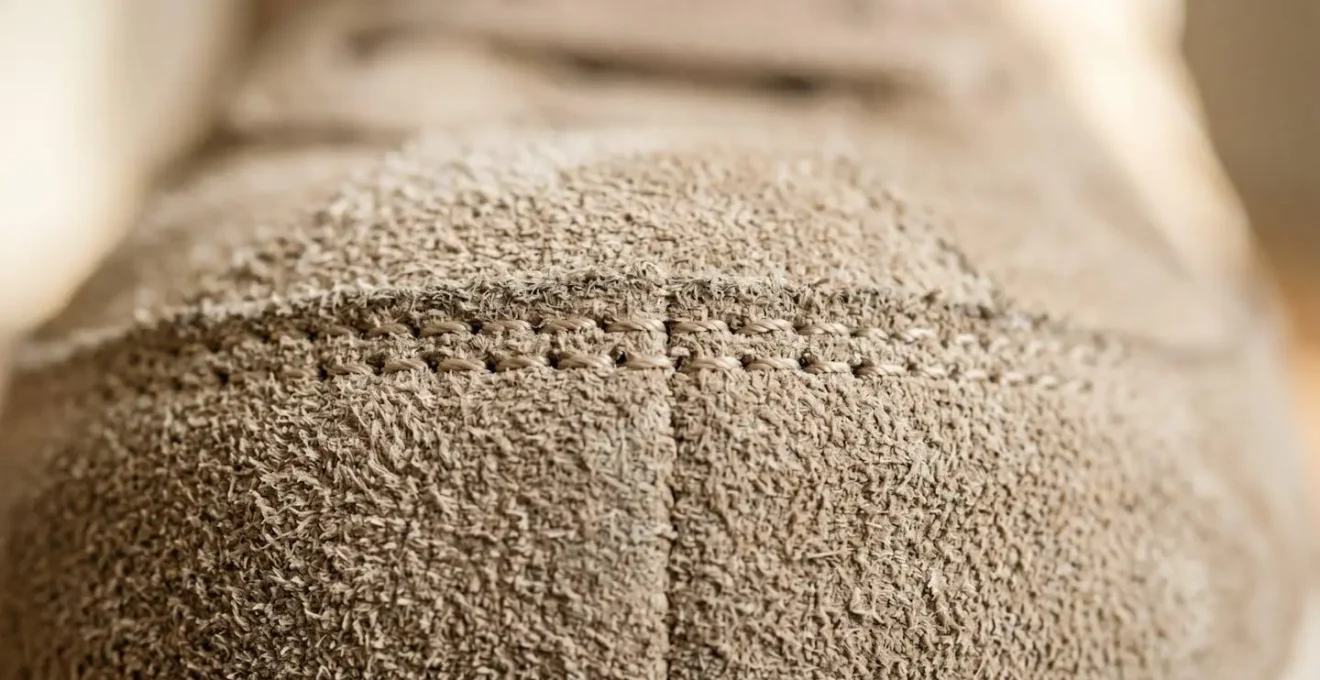 Gros plan sur la texture d'une basket en daim beige avec détails de couture