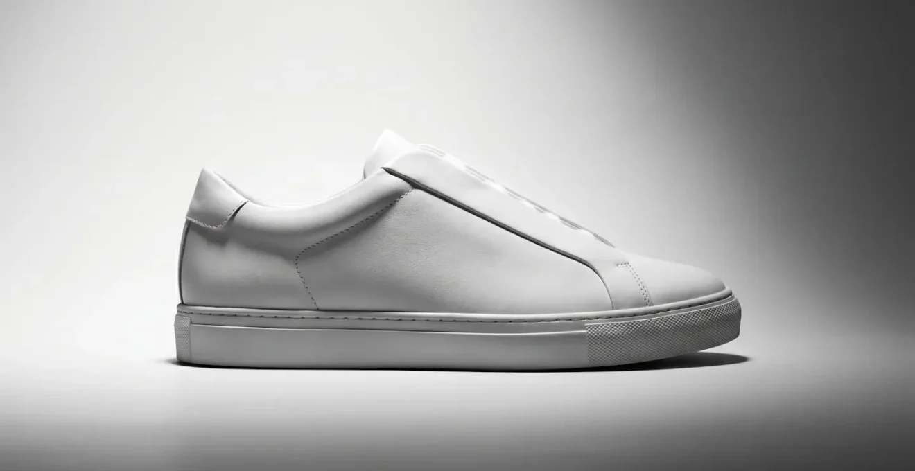 Sneaker blanche vue de profil avec laçage totalement invisible sur fond minimaliste