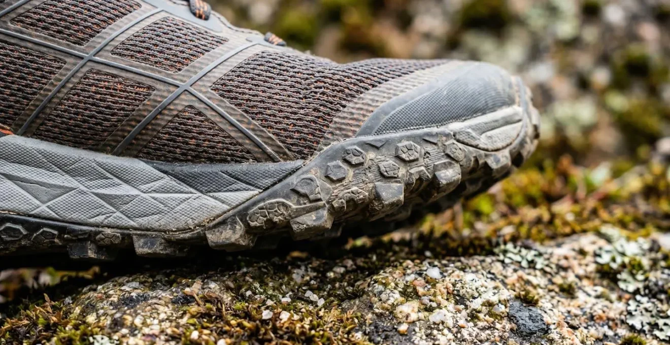 Paire de trail runners techniques photographiée en macro sur surface rocheuse naturelle