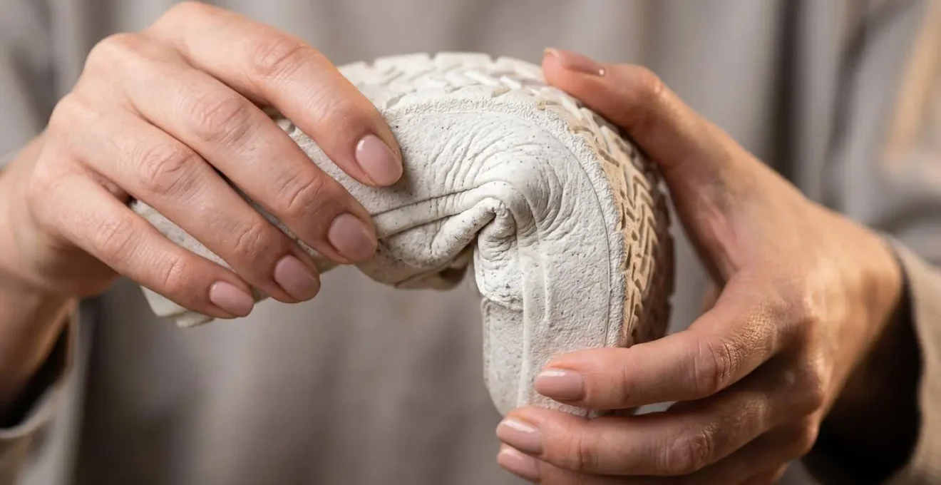 Gros plan sur des mains testant la flexibilité d'une semelle de sneaker compensée